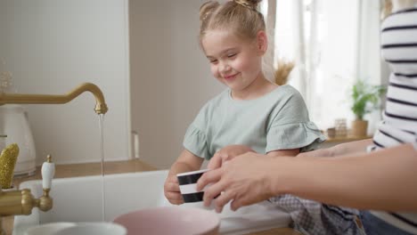 close up video of girl helps her mother to wash dishes