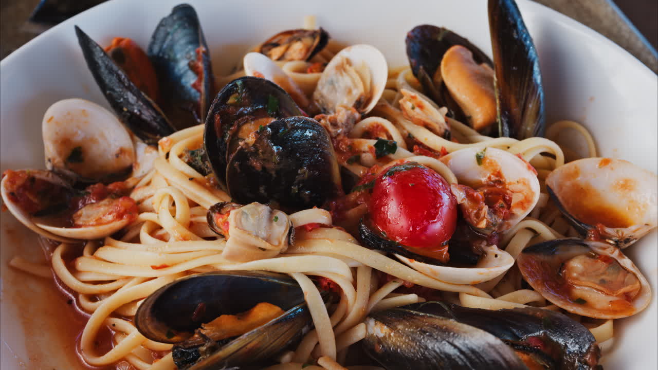Primo piano di un piatto di pasta con frutti di mare e salsa di pomodoro in un ristorante