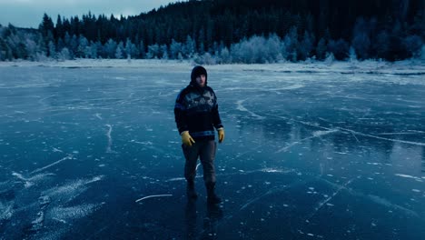 norwegian man walking in the frozen omundvatnet lake in winter in indre fosen, trondelag, norway