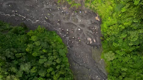 Vista-Aérea,-Flujo-De-Río-De-Lava-Fría-Del-Monte-Merapi-Y-Camiones-Visibles-Y-Mineros-De-Arena-En-Movimiento