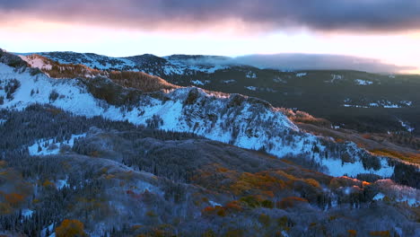 primera luz kebler paso cresta butte gunnison colorado temporadas accidente aéreo dron temprano en el otoño árbol de aspera rojo amarillo bosque naranja invierno primera nieve frío amanecer nube cimas rocosas de las montañas izquierda movimiento