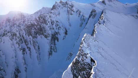 the-camera-flies-towards-a-snow-covered-white-mountain-and-reveals-a-big-rocks