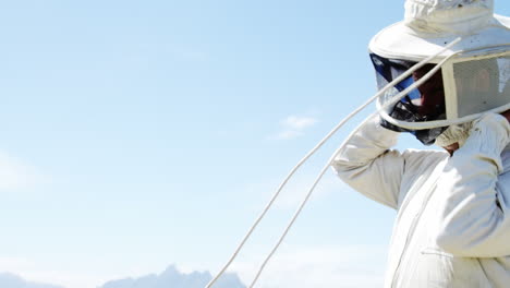 beekeeper wearing protective mask in apiary