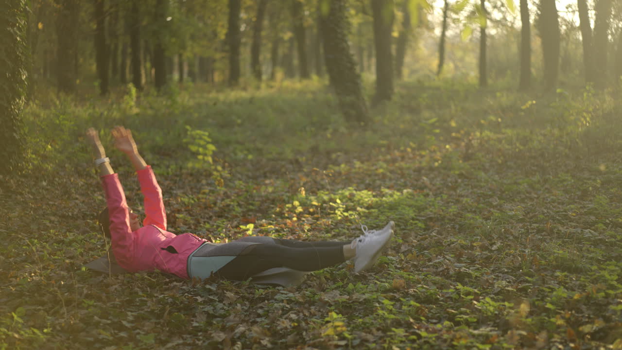 Woman doing exercises in a park during autumn