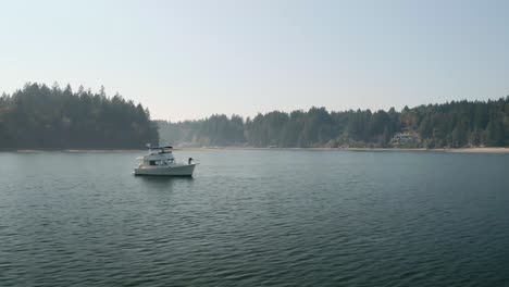 Yate-Blanco-Flotando-En-Las-Tranquilas-Aguas-De-Mayo-Cove-Cerca-Del-Parque-Estatal-Penrose-Point-Durante-El-Día-En-Lakebay,-Estado-De-Washington,-Estados-Unidos