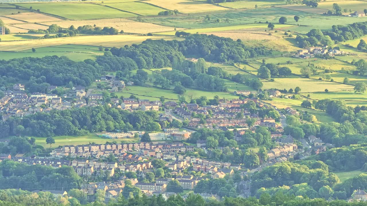 A harmonious blend of urban and rural elements, where lush green hills and trees surround a community of houses and buildings, creating a picturesque and serene landscape.