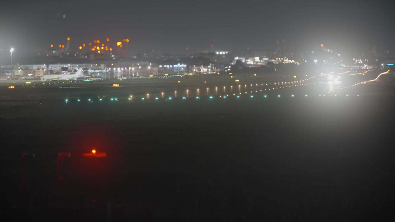 Aereo in atterraggio sulla pista dell'aeroporto di notte.