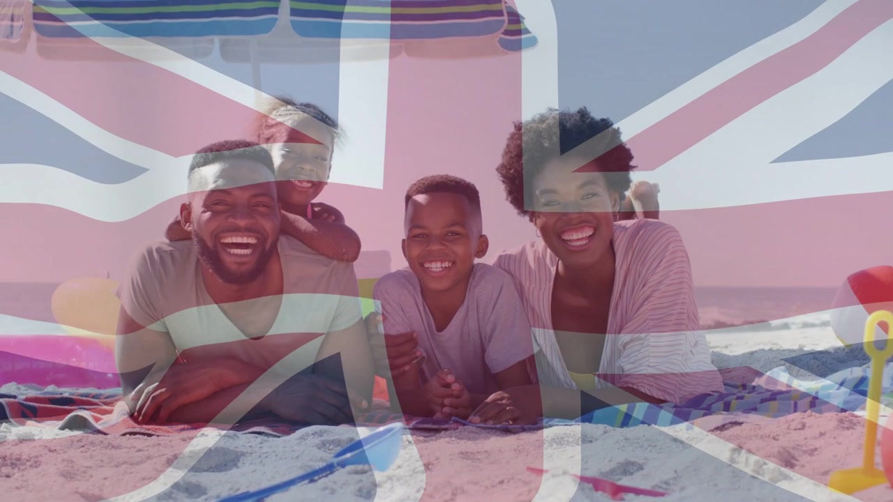 Camera loopt, familie poseert voor een reisfoto op zand terwijl een Union Jack-overlay het beeld bedekt.