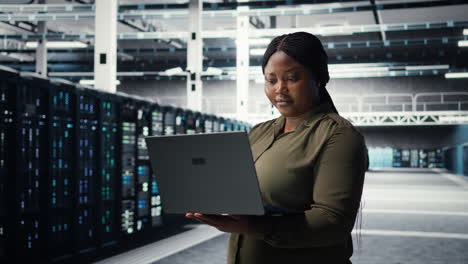 Engineer using laptop in data center, integrating new technologies