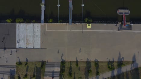 disparo de un dron que viaja a la izquierda de un paseo junto a un río durante el día
