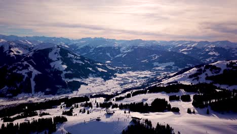 snowy mountains in low clouds and blue sky in winter