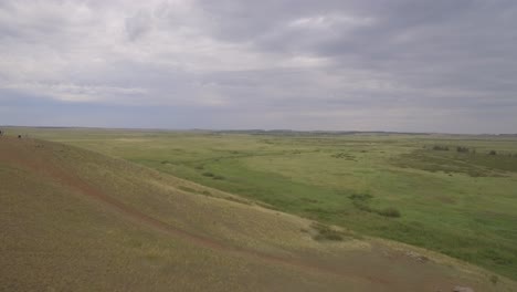 vista aérea de una llanura de hierba con colinas y personas