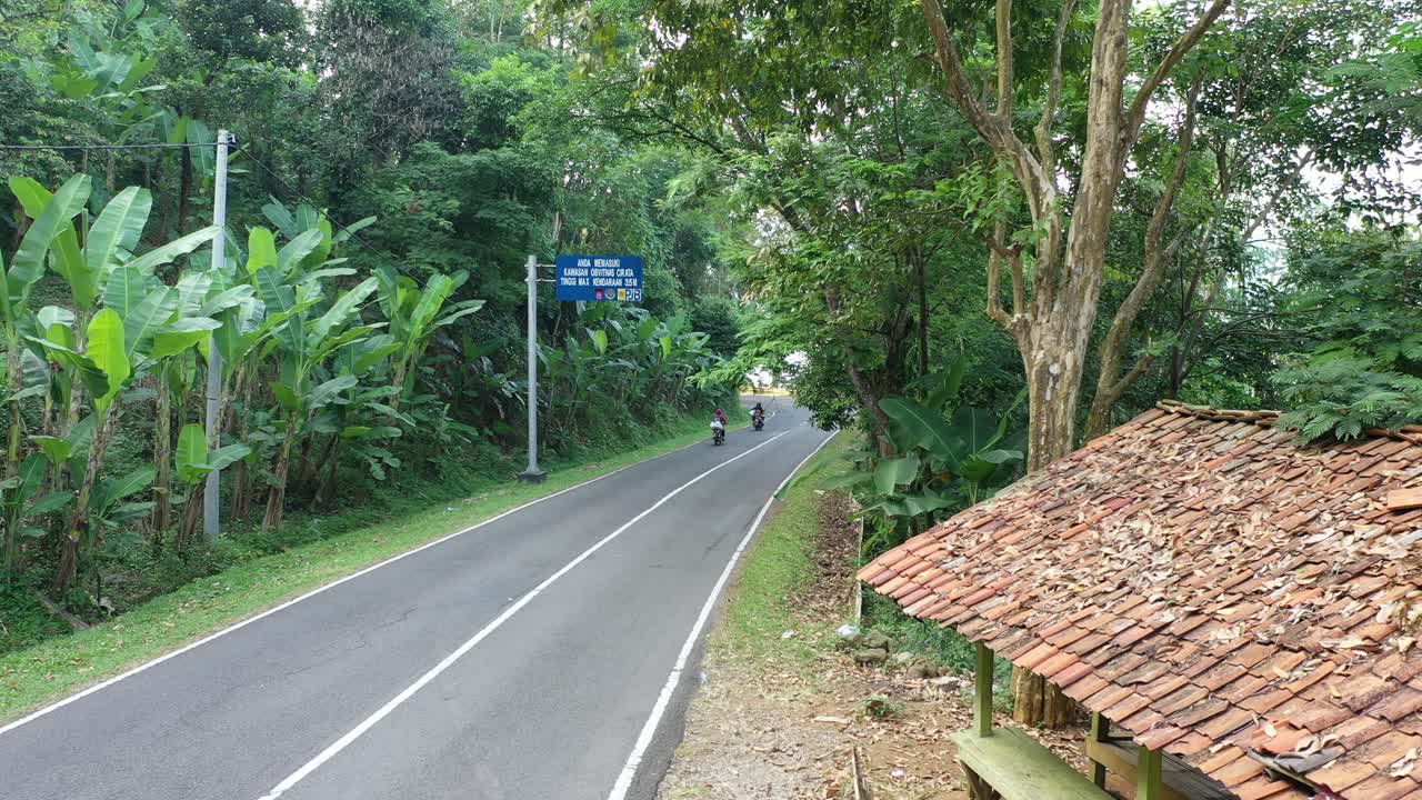 Scenic Mountain Road with Tropical Vegetation and Motorbikes