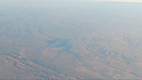 Punto-De-Vista-Desde-La-Ventana-Del-Avión-Que-Muestra-La-Cordillera-De-La-Tierra-Roja-Y-El-Lago-En-La-Parte-Inferior-Derecha-De-La-Ciudad-En-La-Parte-Inferior-Derecha-De-La-Pantalla-Con-El-Río-Que-Fluye-Hacia-La-Ciudad-Desde-La-Mitad-De-La-Pantalla-En-El-Interior-De-Australia