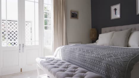 general view of bedroom interior with bed and big window