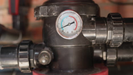 the operation of the pool filter in cleaning mode. in the frame you can see a viewing window with a stream of water and debris. the manometer shows the water pressure. swimming pool maintenance