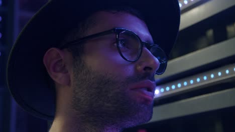 bearded hipster man looking in distance with futuristic sparkling neon lights