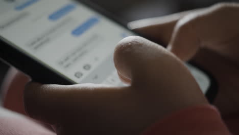 close-up of child's hands typing in messaging app on smartphone