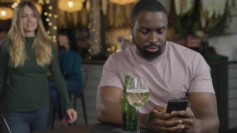 tracking shot of woman joining a man in a bar