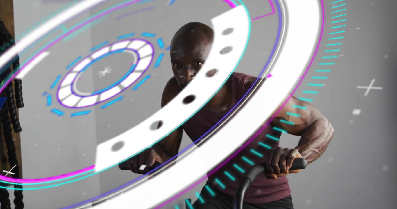 Spinning digital HUD overlay initiating fitness data display, while man pedaling bike in studio