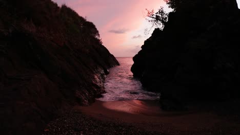 amazing red and blue sky revealed through a rock channel on the ocean shore at fort bennett in tobago.