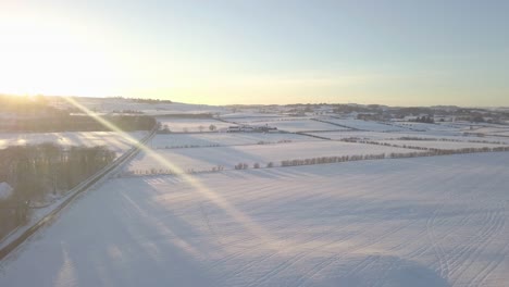 Paisaje-Invernal-Con-Una-Casa-Y-Campos-Cubiertos-De-Nieve-Blanca-Hasta-El-Horizonte-En-Un-Día-Frío-Y-Brillante-En-Escocia-Durante-La-Hora-Dorada-Mientras-El-Sol-Está-En-La-Cima-De-La-Colina