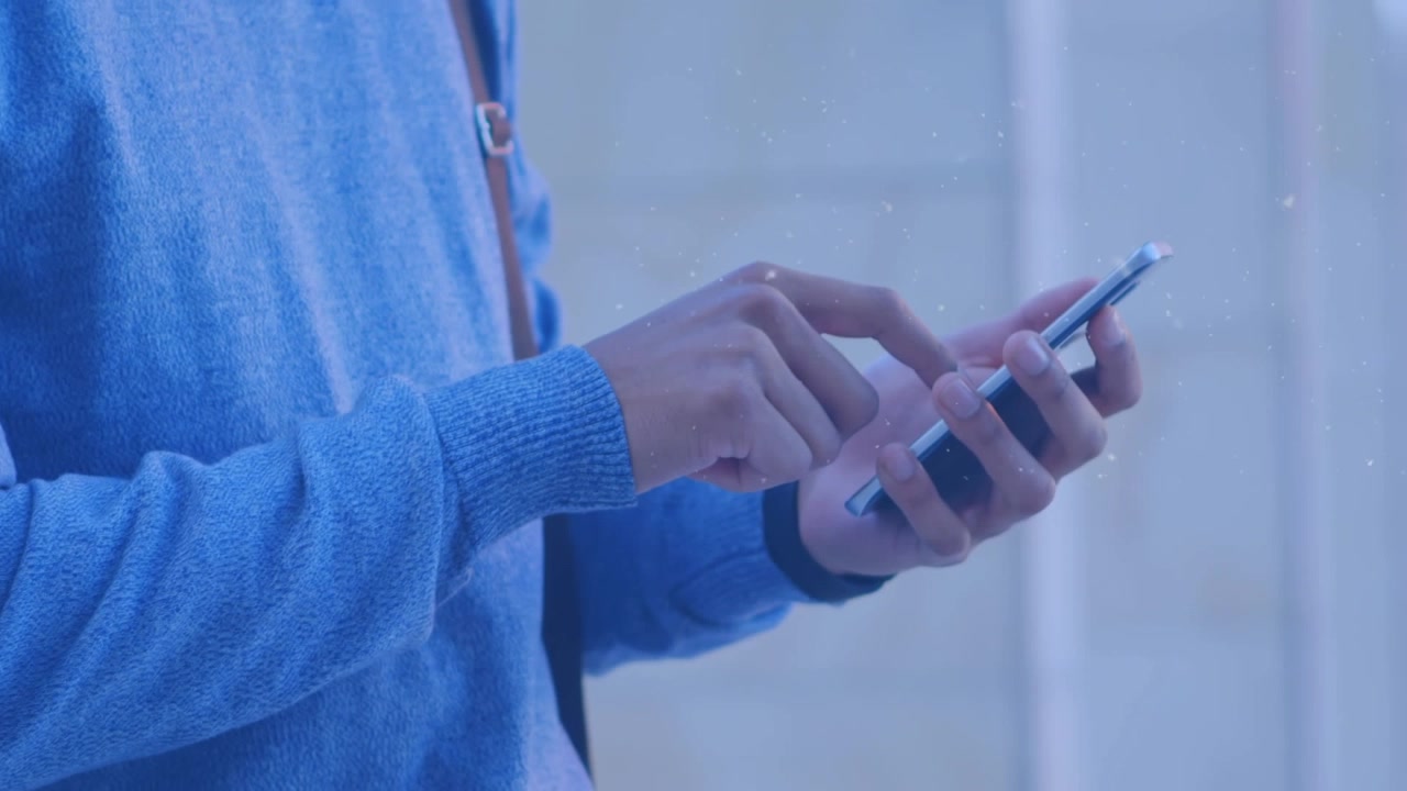 Animacja opadów śniegu nad tułowiem kaukaskiego mężczyzny używającego smartfona.