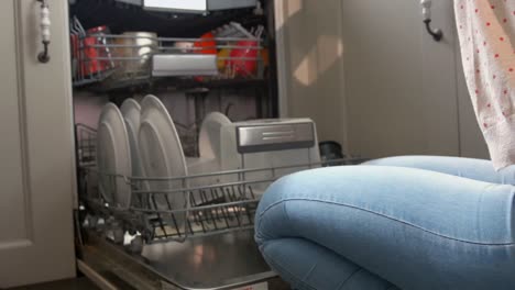 Pretty-young-woman-using-the-dishwasher