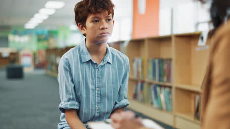 a young redhead boy in a library talking to someone