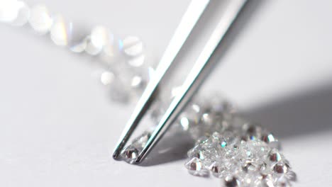 a goldsmith in jewelry checks the quality of luxury brilliant diamonds. the diamonds of high caliber shine the light and pure.