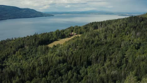 sunny aerial view of house next to the lake between norway mountains