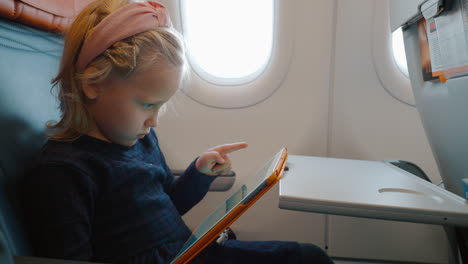 child using digital tablet in the airplane