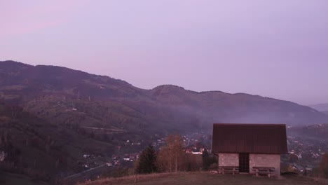 scenic view of ridges with tranquil village during misty morning in piatra craiului mountain, brasov county, romania, panning right shot