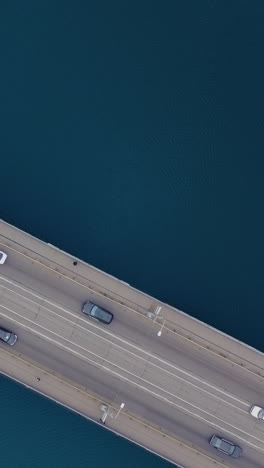 road bridge over the water. traffic cars on the bridge. aerial top view of traffic. vertical video