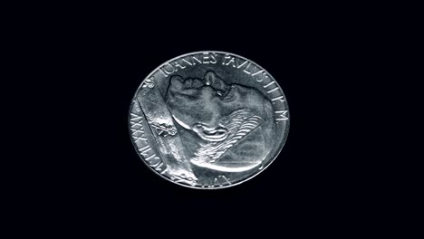 coin ioannes pavlvs ii p m a vii mcmlxxxv citta del vaticano 100 lire rotates on a black background. macro. closeup