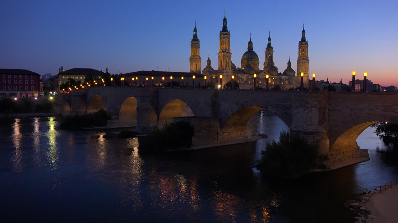 Un classico e bellissimo ponte in pietra a Saragozza, Spagna al tramonto con sfondo di cattedrale cattolica