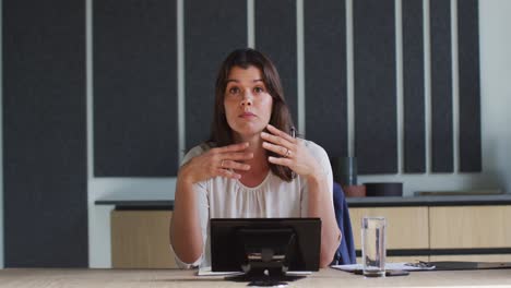 Caucasian-businesswoman-talking-on-video-call-in-conference-room-in-modern-office