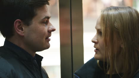 man and woman talking vividly in lift