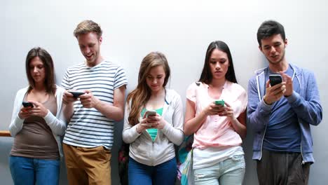 classmates standing in a row and text messaging