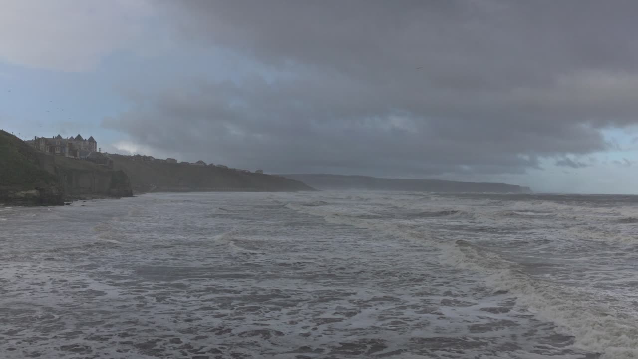 static shot of storm waves crashing along the beaches at the Whitby coast