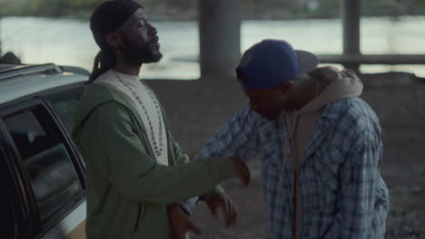 two african american men quarreling and pushing each other under overpass