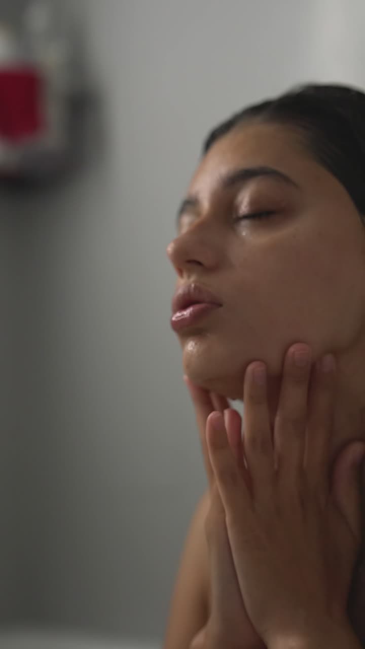 una mujer lavándose la cara