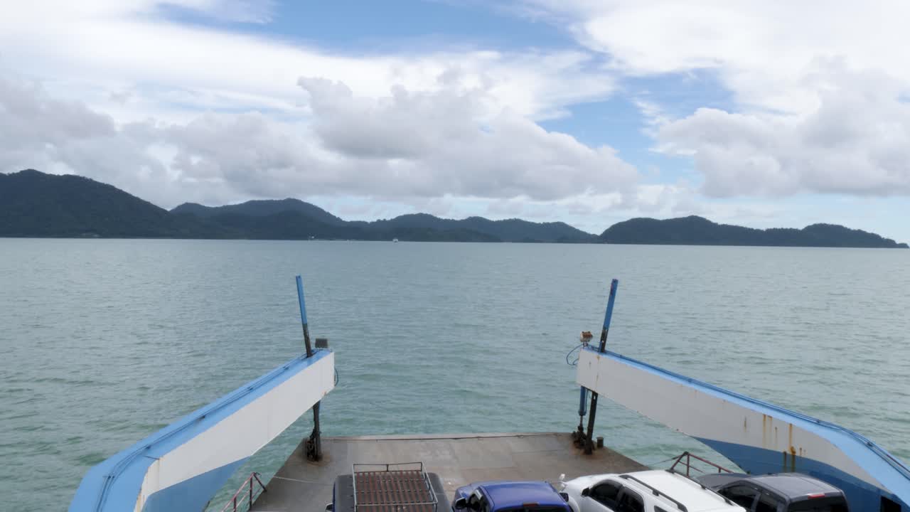 Fährfahrt nach Koh Chang mit Autos an Bord, ruhiger See und bewölktem Himmel