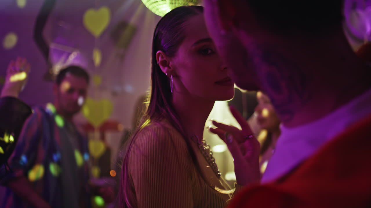 Dancing woman looking boyfriend with magnetic gaze at party atmosphere closeup