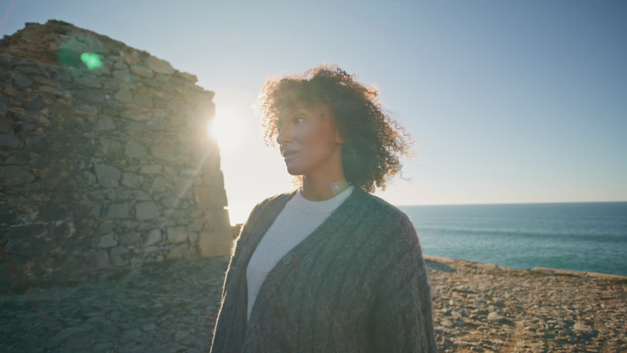 Sad girl walking cliff edge sunny day closeup. Thoughtful woman admiring ocean