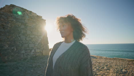 sad girl walking cliff edge sunny day closeup. thoughtful woman admiring ocean