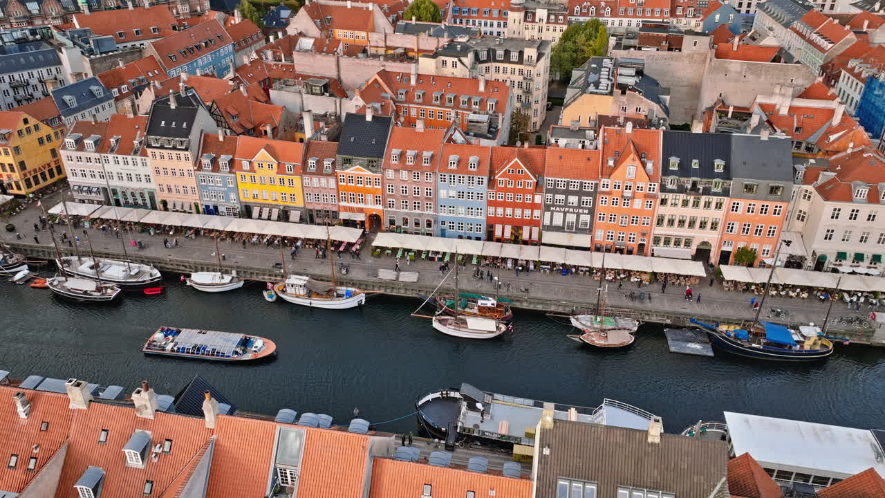 Aerial drone view of boats on the Nyhavn waterfront, canal and entertainment district in Copenhagen, Denmark in daylight