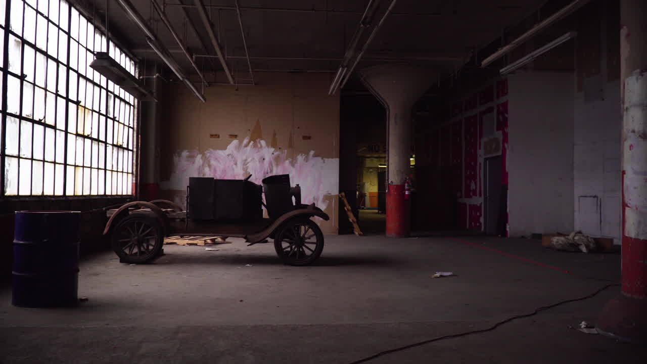 Rusty car in an abandoned warehouse next to stained glass