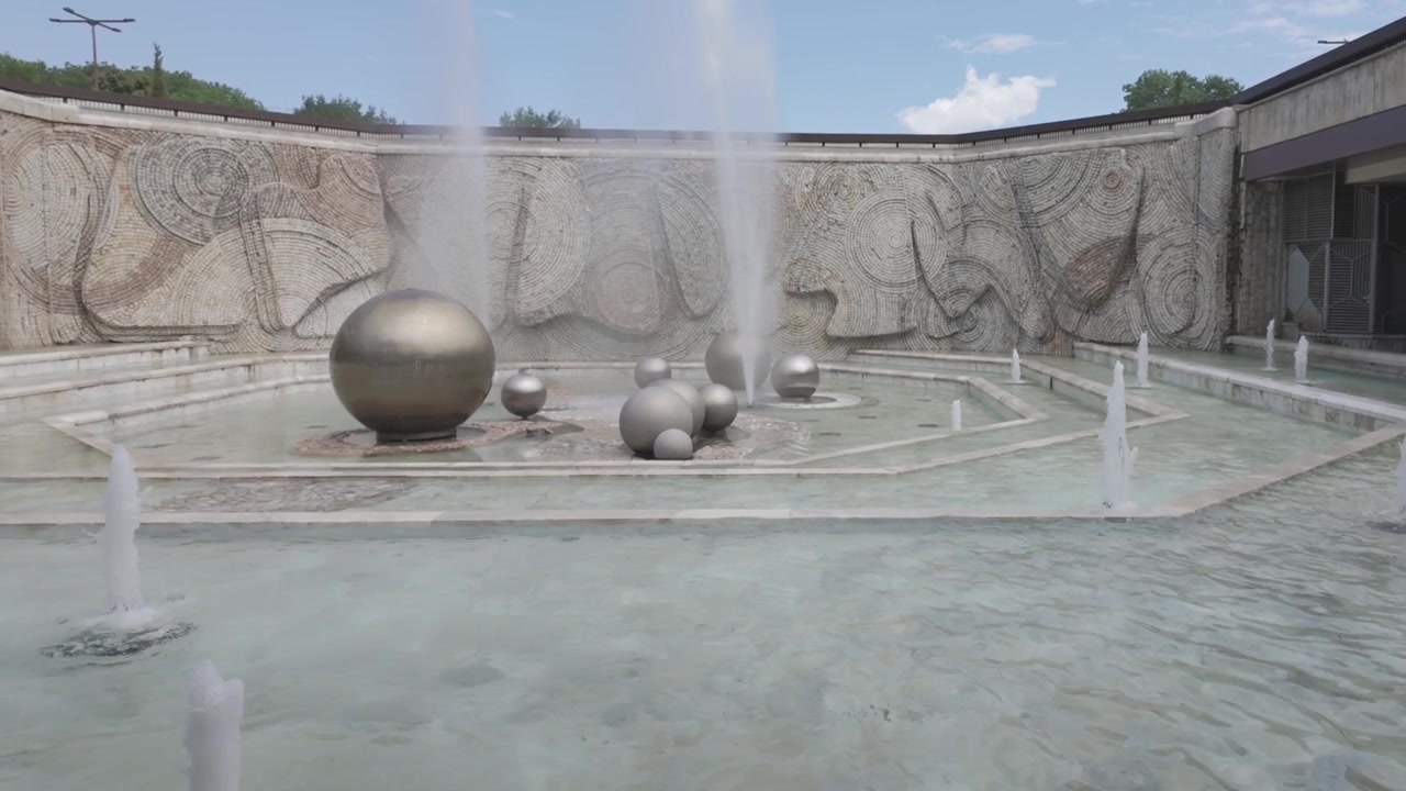 Toma de video panorámica 4K de una fuente hermosa pero inusual con bolas de varios tamaños y obras de arte en Sofía, Bulgaria