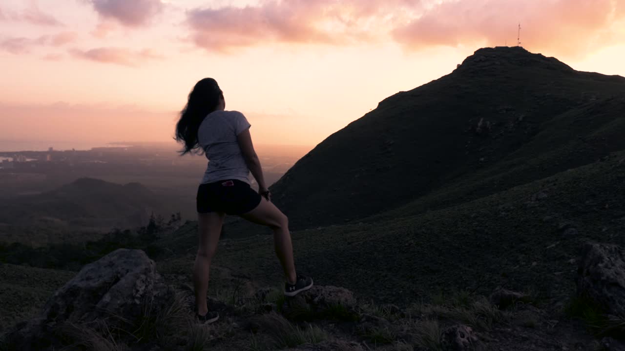 imágenes de drones de una mujer en la cima de una montaña disfrutando de la vista